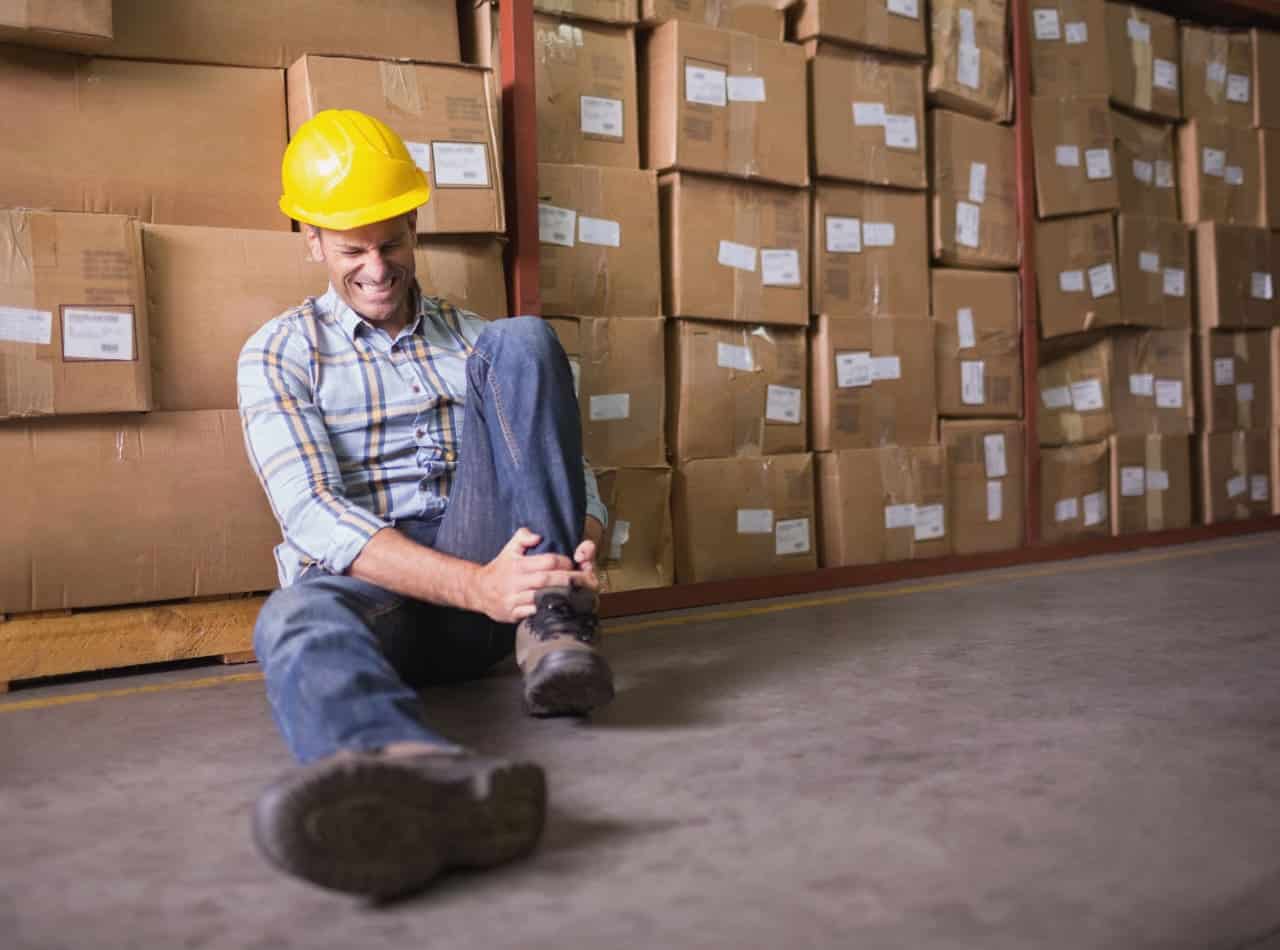 A man experiencing a foot injury during his work