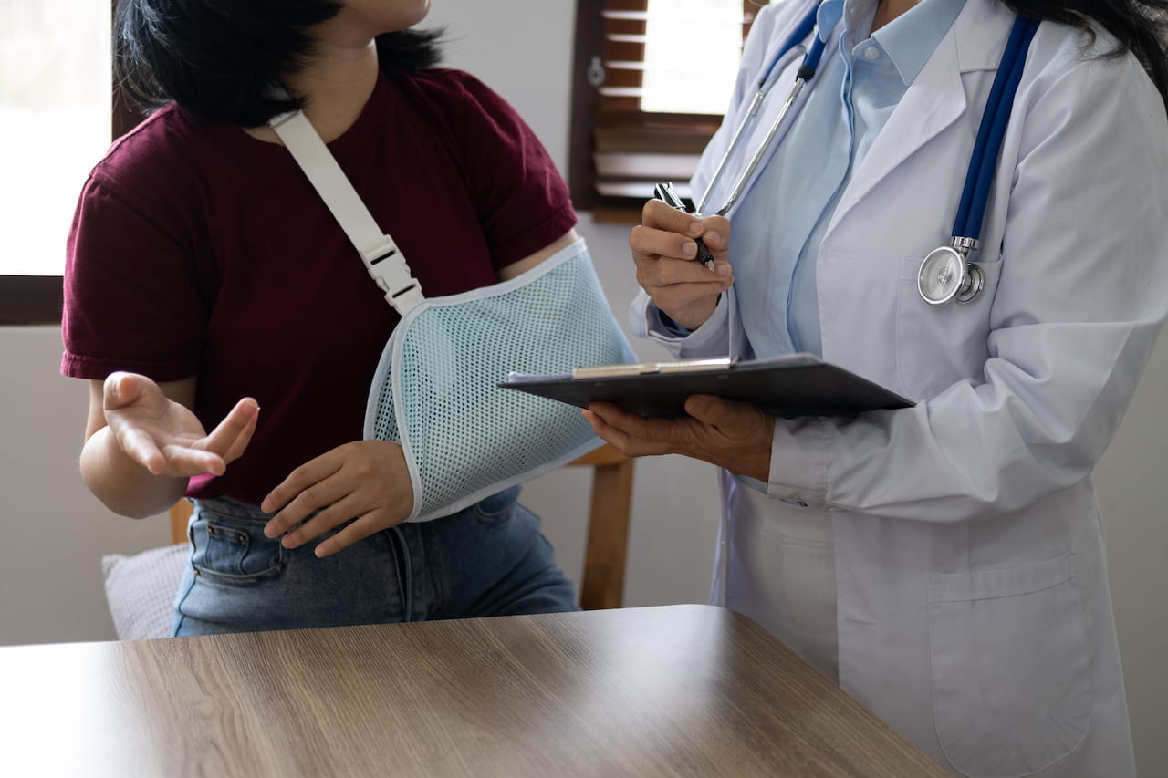A doctor talking to his lady patient about the injury
